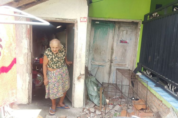 Nenek Warti keluar dari rumah mungilnnya di Gang IV, Jalan Ciliwung, Kelurahan Taman, Kecamatan Taman, Kota Madiun, Jawa Timur. 