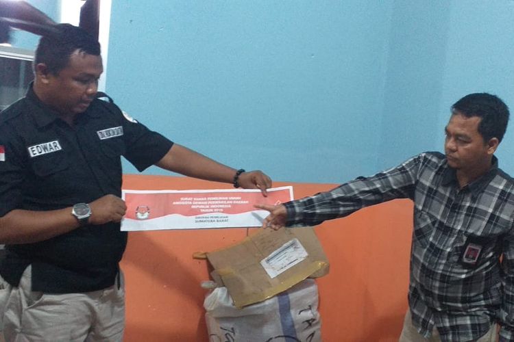 Divisi Hukum Data dan Informasi Bawaslu Kampar, Edwar (baju hitam) memperlihatkan surat suara yang ditemukan di bawah jembatan di Kecamatan Salo, Kabupaten Kampar, Riau, Senin (15/4/2019).