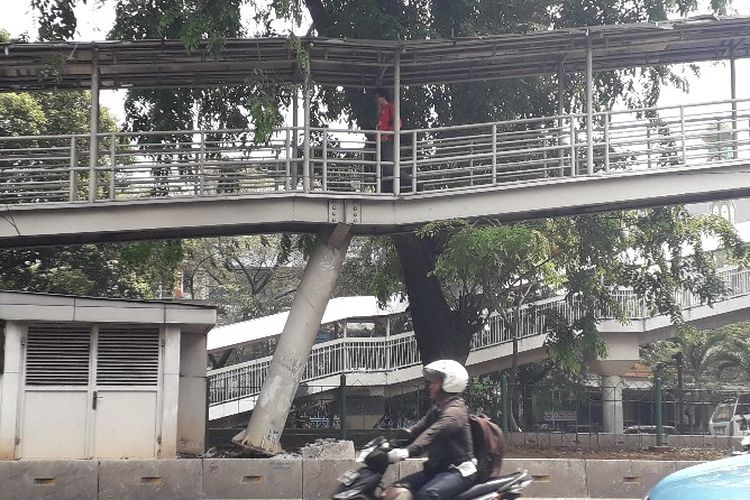 Tiang jembatan penyeberangan orang (JPO) di dekat RS Sumber Waras, Jakarta Barat, miring dan terlepas dari alas beton akibat ditabrak bus transjakarta,  Selasa (25/9/2018) pagi pukul 06.08 WIB.