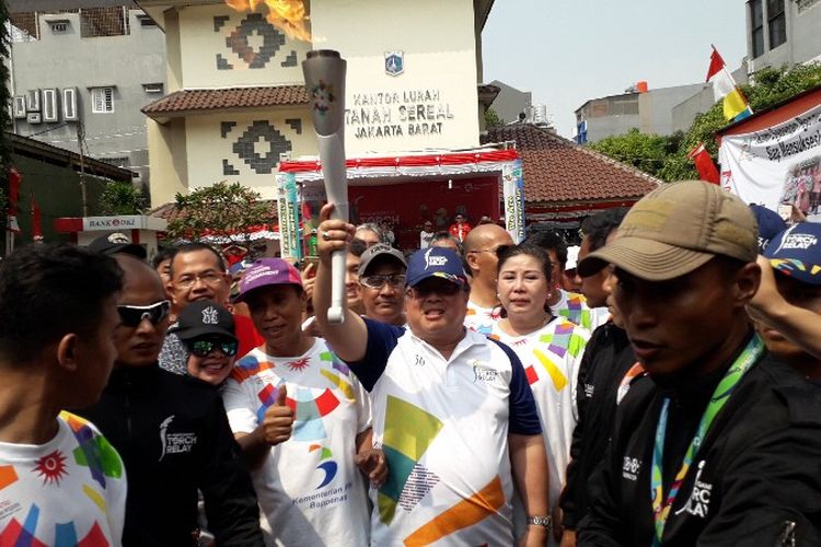 Menteri Perencanaan Pembangunan Nasional Indonesia Bambang Brojojonegoro menjadi salah satu pelari yang membawa obor dalam torch relay Asian Games 2018 di titik Kelurahan Tanah Sereal, Jakarta Barat pada Kamis (16/8/2018).