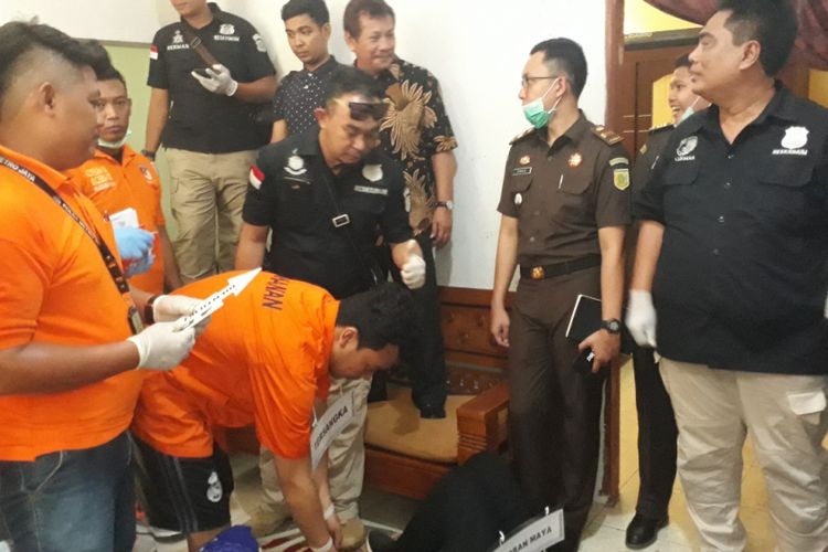 Haris Simamora tersangka pembunuhan satu keluarga di Bekasi saat memeragakan adegan rekonstruksi di rumah korban, Jalan Bojong Nangka II, Kecamatan Pondok Melati, Kota Bekasi, Rabu (21/11/2018).