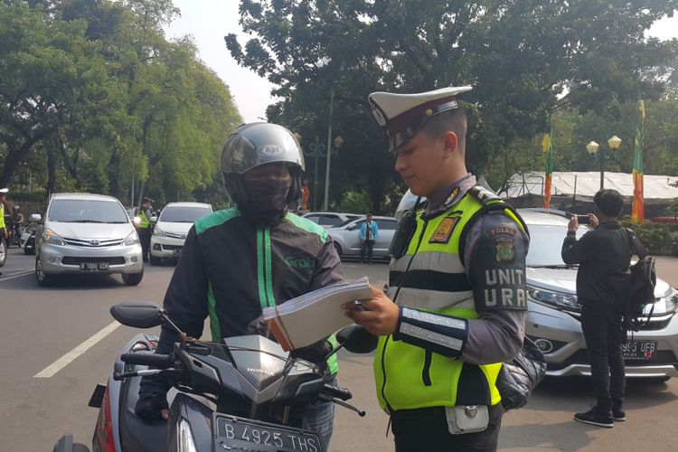 Polisi menilang pengendara sepeda motor yang belum membayar pajak kendaraan bermotor (PKB)-nya di Jalan Lapangan Banteng Selatan, Jakarta Pusat, Jumat (11/8/2017).