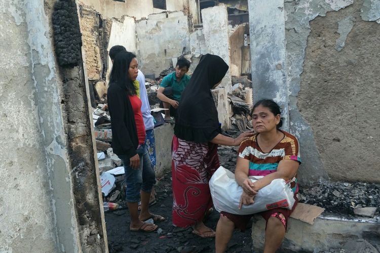 Enung (57), warga Kelurahan Krukut, Tamansari, Jakarta Barat, meratapi rumahnya yang terbakar pada Sabtu (27/1/2018) dini hari.