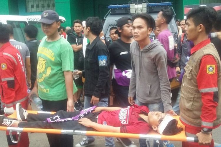 Korban kerusuhan antarsuporter Persita Tangerang dan PSMS Medan di Stadion Mini Cibinong, Kabupaten Bogor, Rabu (11/10/2017) sore WIB, ditandu untuk mendapatkan perawatan.