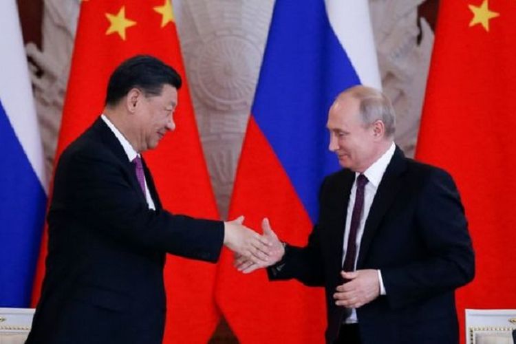 Presiden China Xi Jinping ketika berjabat tangan dengan Presiden Rusia Vladimir Putin saat berkunjung ke Moskwa pada Rabu (5/6/2019).