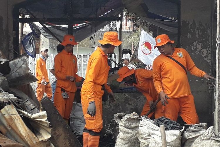 Petugas PPSU membersihkan sampah-sampah bekas kebakaran di Jalan Perumahan Taman Kota, RT 16 RW 05, Kebakatan Utara, Kebakaran, Jakarta Barat pada Senin (2/4/2018).