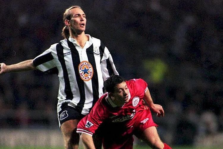 Striker Liverpool Robbie Fowler jatuh di depan Daren Peacock dari Newcastle dalam pertandingan FA Carling Premiership di St James Park 23 Desember.