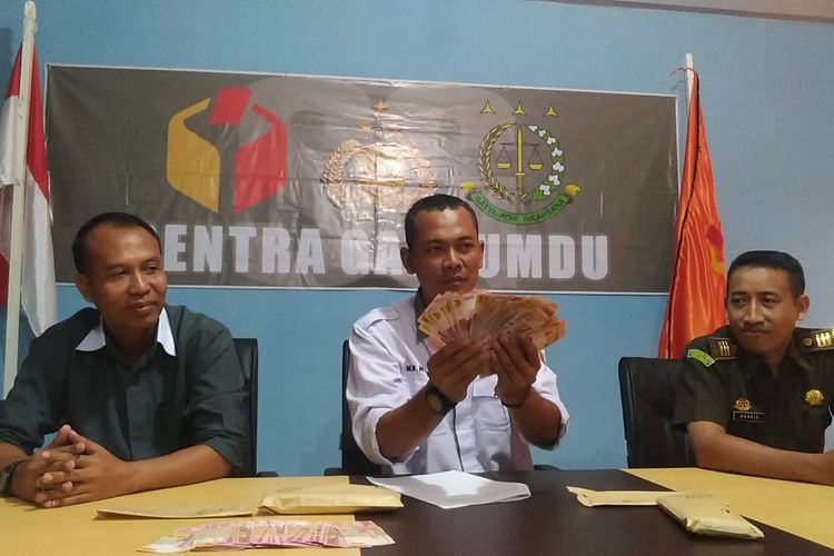 ‎Ketua Bawaslu Kabupaten Kudus, Moh Wahibul Minan menunjukkan barang bukti uang yang diduga akan disebarkan AS dan AH saat jumpa pers di Bawaslu Kudus, Selasa (16/4/2019).