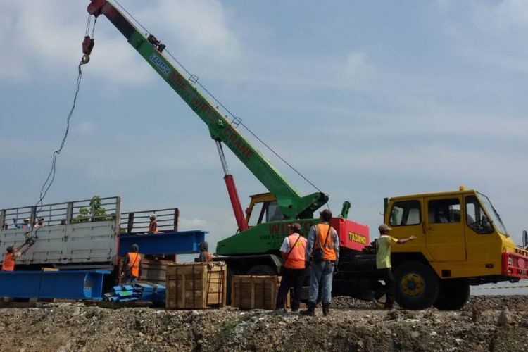 Alat berat sementara menurunkan material untuk proyek double track rel kereta api di wilayah Kabupaten Madiun, Selasa ( 16/5/2017) siang.