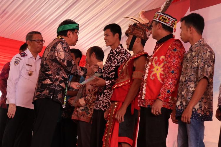 Menteri Agraria dan Tata Ruang, Sofyan Djalil memberikan sertifikat kepada salah seorang warga di Rumah Radangk, Pontianak, Kalimantan Barat, Rabu (24/4/2019).