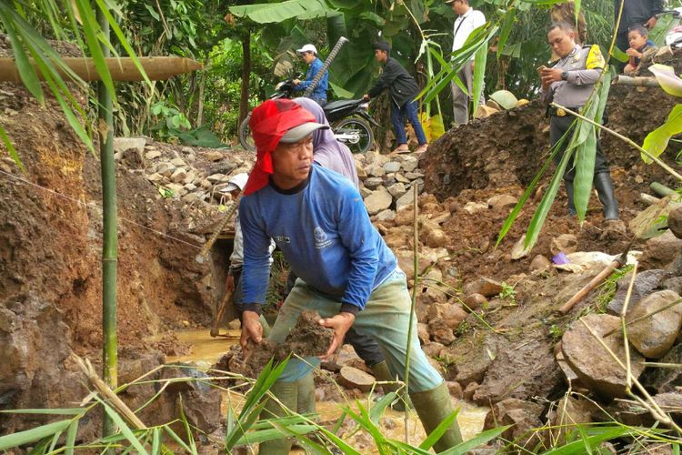 Warga bergotongroyong memperbaiki jalan putus di Desa Bencoy, Kecamatan Cireunghas, Sukabumi, Jawa Barat, Minggu(29/10/2017). 