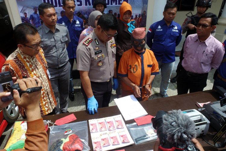 Kapolres Kebumen, Ajun Komisaris Besar Arief Bahtiar menunjukkan barang bukti dan tersangka pengedar uang palsu dalam pers rilis di Mapolres Kebumen, Selasa (14/8/2018).