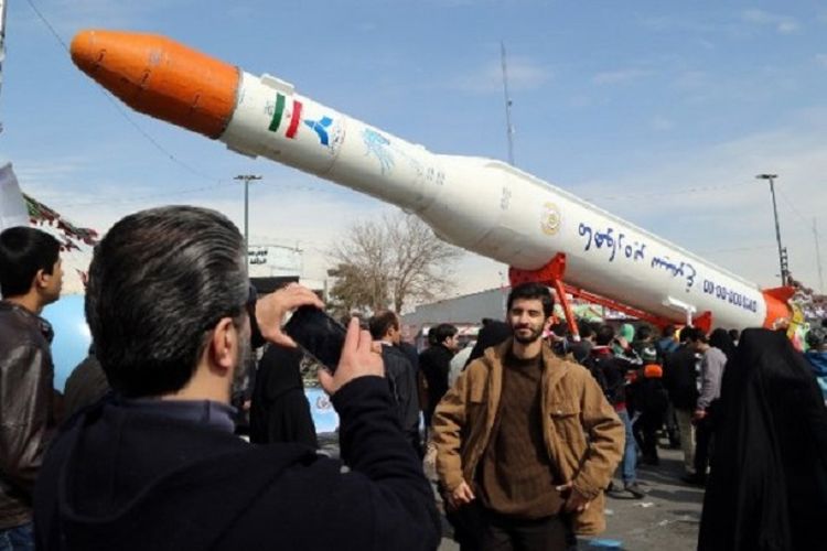 Warga Iran berpose di depan roket satelit Simorgh selama perayaan untuk memperingati 37 tahun Revolusi Iran di Teheran, 11 Februari, 2016. 