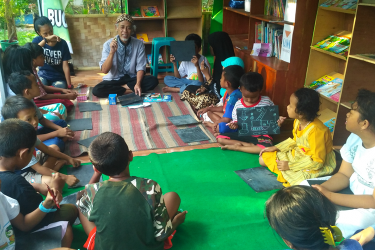 Iman Suligi membawakan materi untuk anak-anak di Kampoeng Batja Suligi di Jember, Jawa Timur.
