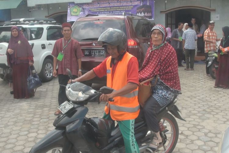 Nenek Damiati pergi ke lokasi pelaksanaan bimbingan haji sendiri menggunakan kendaraan ojek, Selasa (17/7/2018).