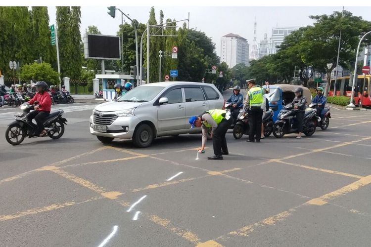 Petugas kepolisian melakukan olah TKP peristiwa tabraka antara Tiara Ayu pengemudi BMW dan driver ojek online di Harmoni, Sabtu (14/4/2018)