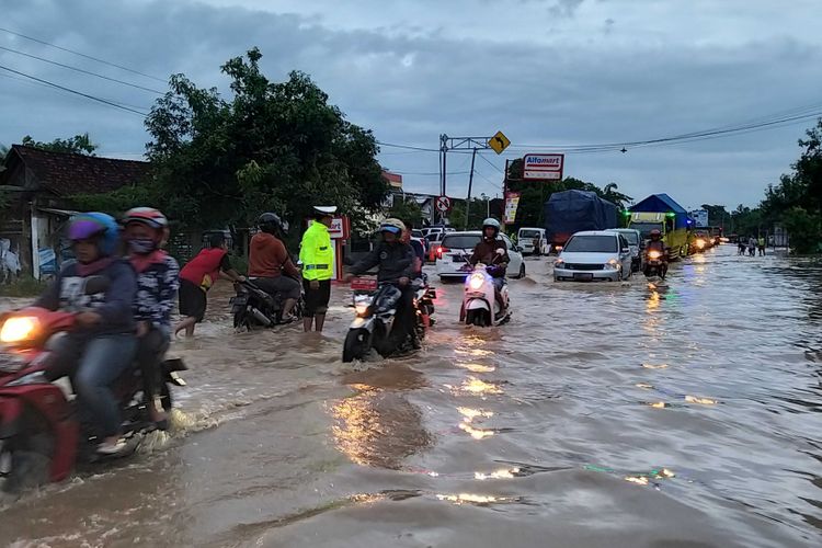 Kasat Lantas Polres Madiun, AKP Imam Mustolich bersama anggotanya mengatur arus lalu lintas di ruas jalan nasional Surabaya-Madiun di Desa Garon, Kecamatan Balerejo, Kabupaten Madiun yang mengalami kemacetan lantaran diterjang banjir, Rabu ( 6 / 3 / 2019) sore.