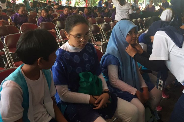 Seorang guru pembimbing membenahi hijab anak didiknya saat menunggu giliran tampil pada lomba paduan suara anak Dendang Kencana yang digelar di Bentara Budaya Jakarta, Palmerah Selatan, Jakarta Pusat, Jumat (27/10/2017).