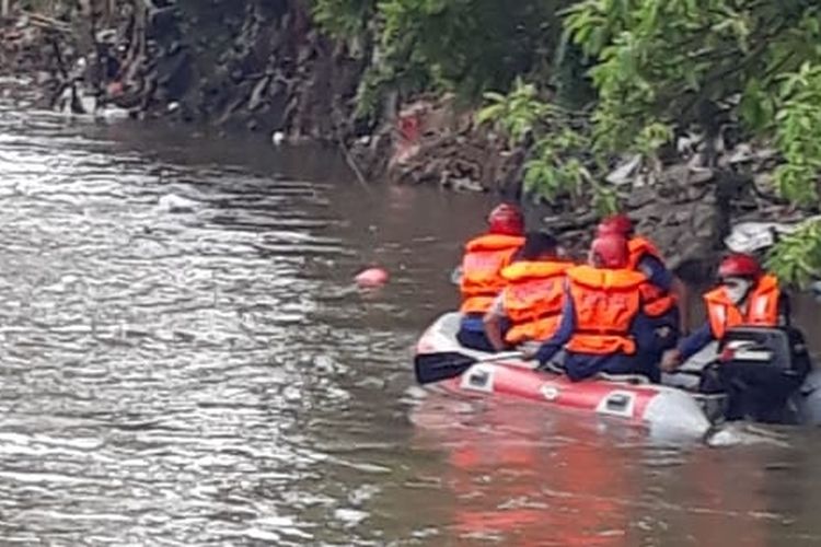 Petugas menyisir Sungai Ciliwung untuk mencari seroang bocah Fikri yang hanyut di sungai tersebut, Selasa (23/4/2019).