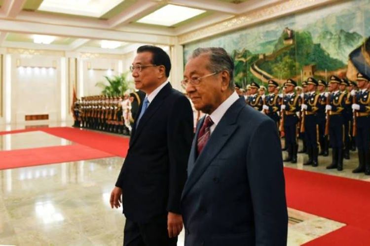 Perdana Menteri Malaysia Mahathir Mohamad (kanan) dan Perdana Menteri China Li Keqiang (kiri) berjalan di Balai Agung Rakyat di Beijing, China, Senin (20/8/2018). (AFP/Wang Zhao)