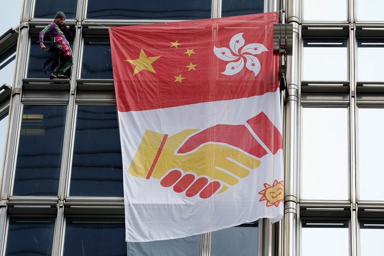 Pemanjat asal Perancis Alain Robert saat memanjat gedung bertingkat Cheung Kong Center di Hong Kong dan membentangkan bendera pesan perdamaian.