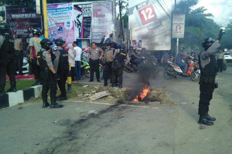 Aparat kepolisian mengamankan situasi depan kampus Unhas Makassar, pasca terlibat bentrokan dengan pendemo bertopeng, Jumat (15/12/2017).