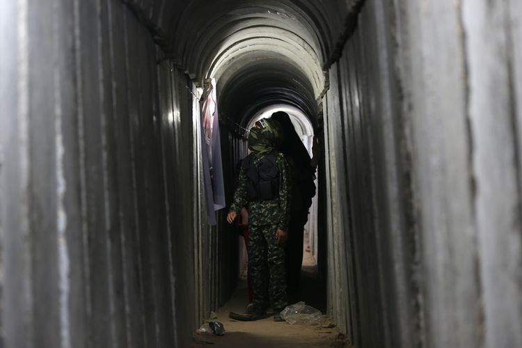 Bocah Palestina berjalan melalui terowongan yang digunakan militer selama latihan dalam eksebisi militer Hamas di Gaza pada Juli 2016.