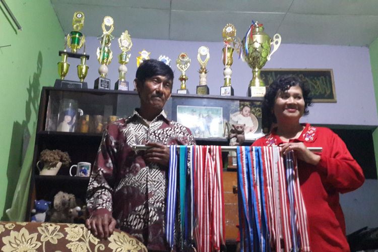 Budi Sutrisno dan Suliasih, orang tua Jafro Megawanto saat menunjukkan medali dan piala anaknya di rumahnya, Kelurahan Songgokerto, Kota Batu, Minggu (26/8/2018)