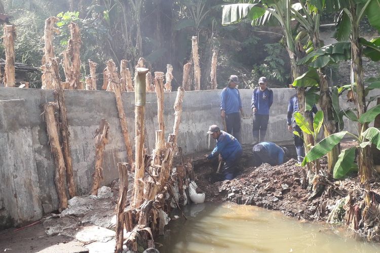 Petugas Suku Dinas Sumber Daya Air memperbaiki tanggul Jatipadang usah jebol, Selasa (2/4/2019).