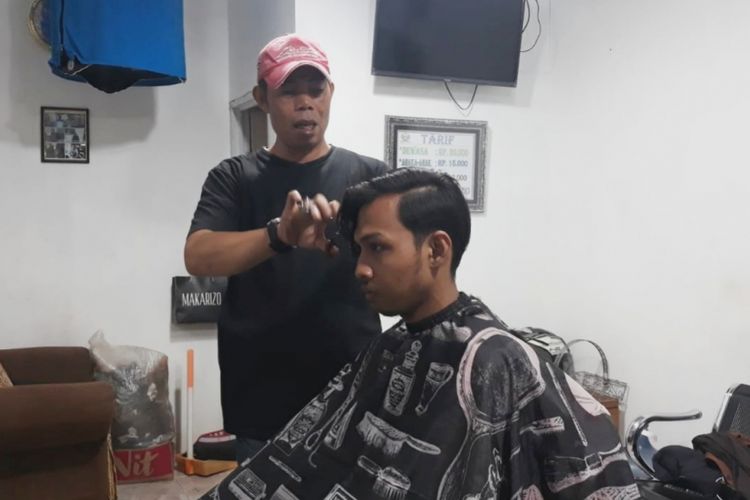 Agus Wahidin (49), tukang cukur pribadi Presiden Republik Indonesi ke-6 Susilo Bambang Yudhoyono (SBY) saat sedang cukur rambut pelanggannya, Jumat (1/2/2019).