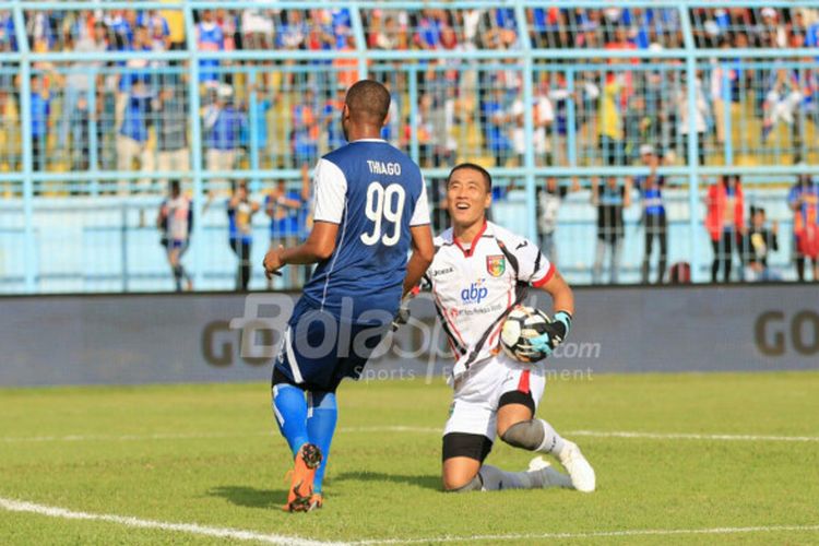 Kiper Mitra Kukar, Yoo Jae-hoon, mengamankan bola dari striker Arema FC, Thiago Furtuoso, dalam duel pekan pertama Liga 1 2018 di Stadion Kanjuruhan, Malang, Sabtu (24/3/2018)