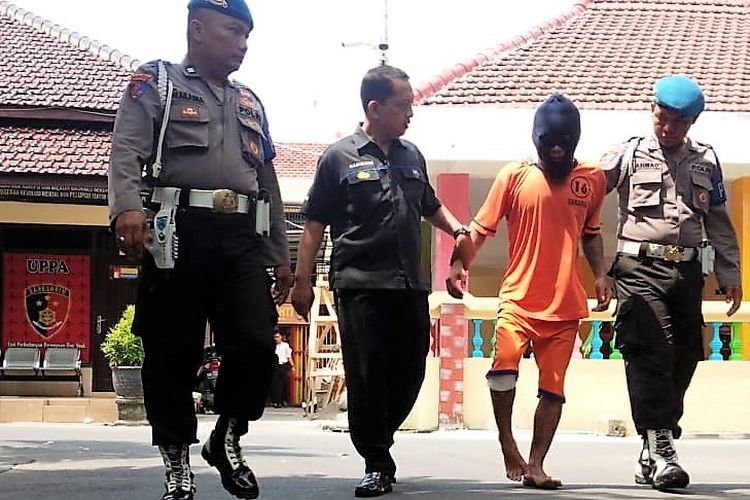 Hudah (30), pelaku pembunuhan saat digelandang petugas di Mapolres Jombang, Kamis (28/2/2019).
