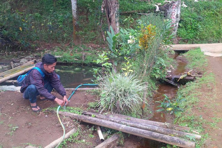 Seorang warga memperbaiki selang pipa air di Kampung Pasir Tengah, Desa GedePangrango, Kadudampit, Sukabumi, Jawa Barat, Rabu (13/6/2018). 