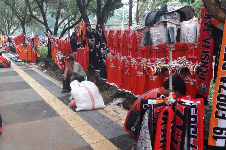Pedagang atribut suporter sepakbola menghelar lapaknya di sejumlah titik di kawasan Gelora Bung Karno, Sabtu (17/2/2018)