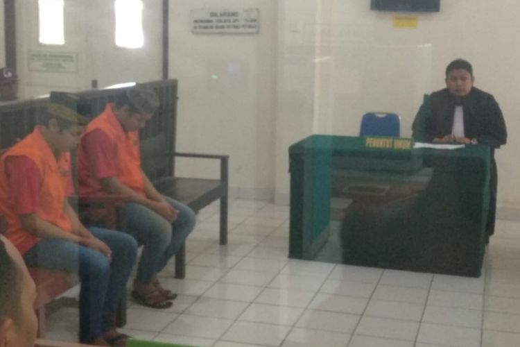 Dua terdakwa Tyas Dryantama (19) dan Bayu Irmansyah (20) ketika menjalani sidang vonis di Pengadilan Negeri (PN) Klas 1 Palembang, Sumatera Selatan. Keduanya divonis oleh majelis hakim dengan penjara seumur hidup lantaran telah terbukti melakukan perampokan disertai pembunuhan terhadap Try Widiantoro yang merupakan sopir taksi online, Rabu (17/10/2018).