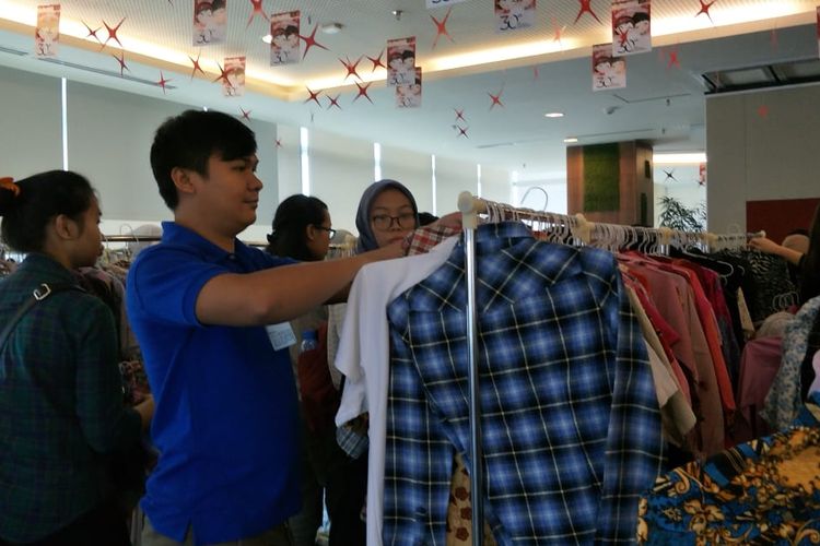 Warga memilih baju dalam event #TukarBaju yang digagas Komunitas Zero Waste Indonesia di DBS Bank Tower, Kuningan, Jakarta Selatan, Sabtu (27/7/2019).