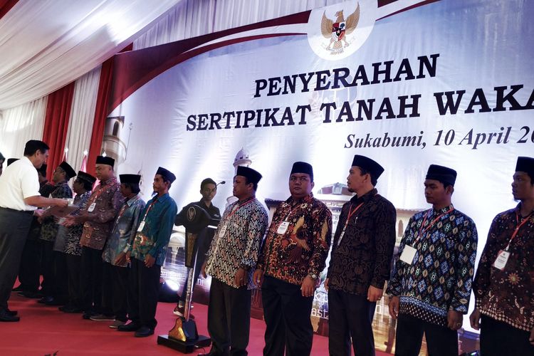 Menko Bidang Kemaritiman Luhut Binsar Panjaitan (kiri) menyerahkan sertifukat tanah wakaf di Sukabumi, Jawa Barat, Rabu (10/4/2019).