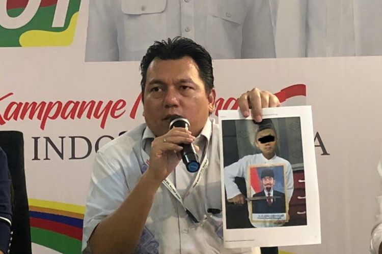 Direktur Direktur Hukum dan Advokasi TKN Jokowi-Maruf Irfan Pulungan menunjukan foto yang diduga bentuk kebencian terhadap simbol negara oleh anak-anak, di Posko Cemara, Jumat (9/11/2018). 