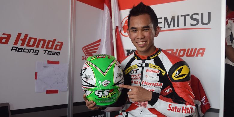 Pebalap Astra Honda Racing Team, Gerry Salim, berpose dengan helm yang dipasangi gambar animasi Jerry si tikus, saat berada di paddock Sirkuit Johor, setelah menyelesaikan sesi pemanasan nomor Asia Production 250cc seri pertama Asia Road Racing Championship, Minggu (2/4/2017).