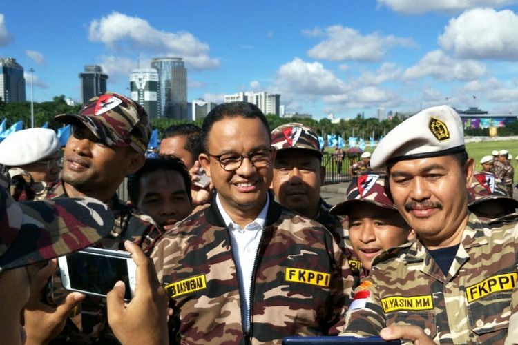 Gubernur DKI Jakarta Anies Baswedan berbaju loreng FKPPI bersama anggota FKPPI di Monas, Sabtu (9/12/2017). 