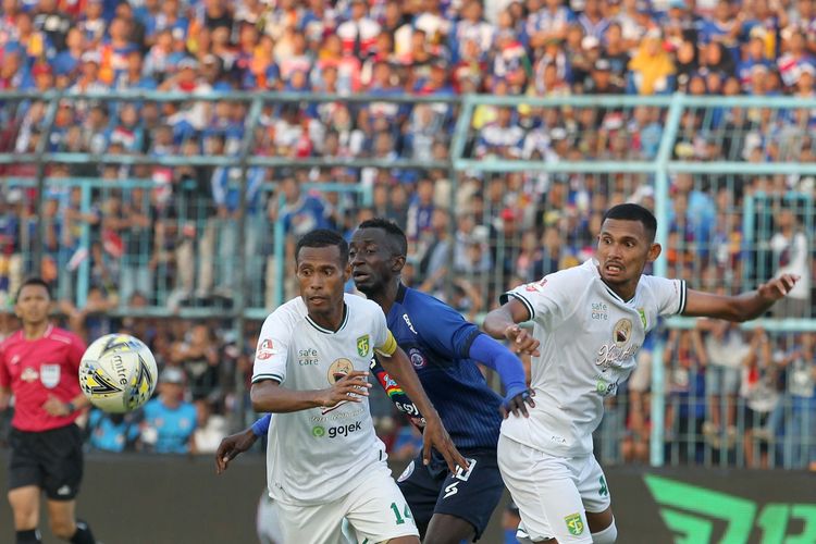 Pemain Arema FC Makan Konate (tengah) dijaga ketat pemain Persebaya Surabaya Ruben Sanadi (kiri) dan Andri Muladi (kanan) saat Pekan 14 Liga 1 2019 yang berakhir dengan skor 4-0 di Stadion Kanjuruhan Kabupaten Malang, Jawa Timur, Kamis (15/082019) sore.
