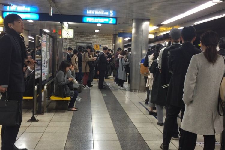 Masyarakat terlihat mengantre menunggu kereta datang pada jam-jam sibuk di jalur yang telah disediakan pengelola stasiun.