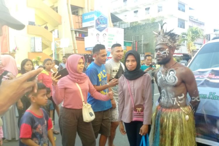 Warga Ambon berebutan foto bersama mahasiswa Papua di acara karnaval musik Ambon, Jumat (6/9/2019)