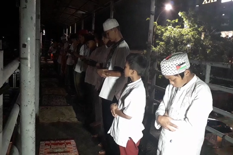 Jemaah mendirikan salat tarawih di atas JPO Pasar Gembrong, Senin (6/5/2019).