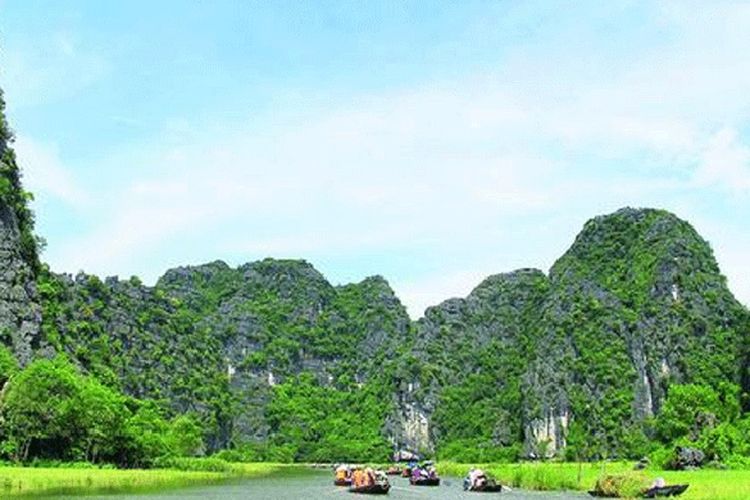 Wisata air berperahu di Sungai Ngo Dong alias Tam Coc. Pengunjung dapat melihat keindahan gugusan batuan kapur tua lebih dekat dari sungai.