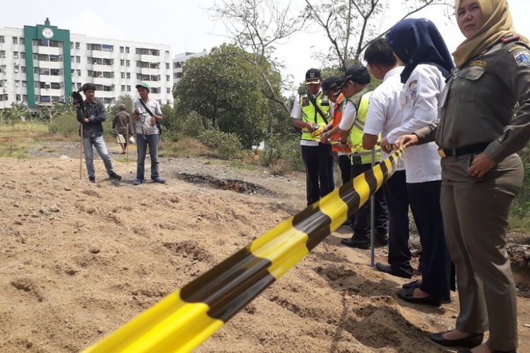Petugas Dinas LH memasang garis pembatas di area temuan gundukan yang diduga limbah B3 di kawasan Marunda, Jakarta Utara, Rabu (9/1/2019).