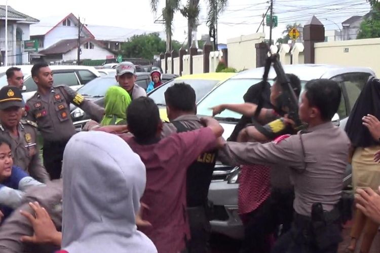 Keluarga korban pembunuhan terlibat adu jotos dengan aparat kepolisian di Pengadilan Negeri Sungguminasa, Kabupaten Gowa, Sulawesi Selatan. Senin, (15/1/2018).