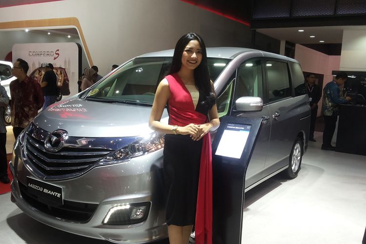 Seorang sales promotion gilr (SPG) memperkenalkan salah satu produk andalan Mazda di stan Eurokars Motor Indonesia saat hari pertama ajang Indonesia International Motor Show (IIMS) 2018 di JIExpo Kemayoran, Jakarta, Kamis (19/4/2018).