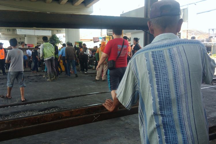 Warga sekitar Jembatan layang Janti, Yogyakarta, menyeberangi perlintasan kereta api yang sudah ditutup bagi kendaraan.