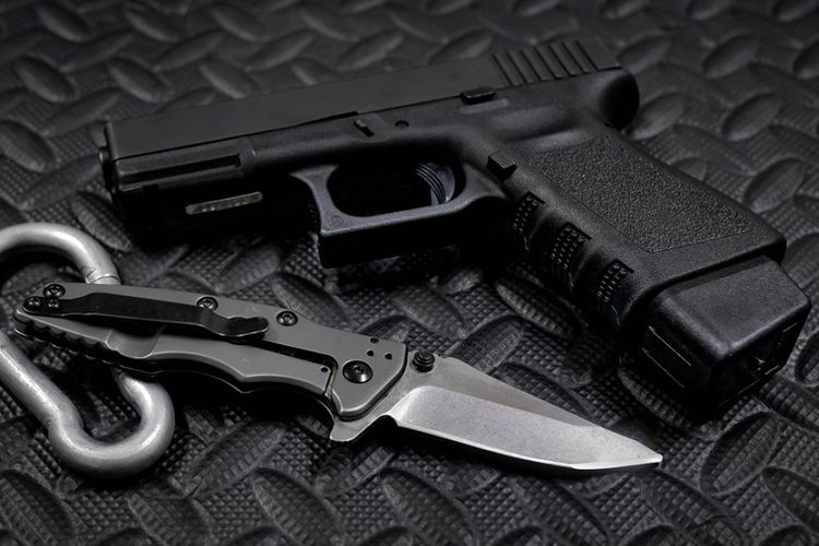 Ilustrasi pistol semi-otomatis Glock 9 milimeter dan pisau.